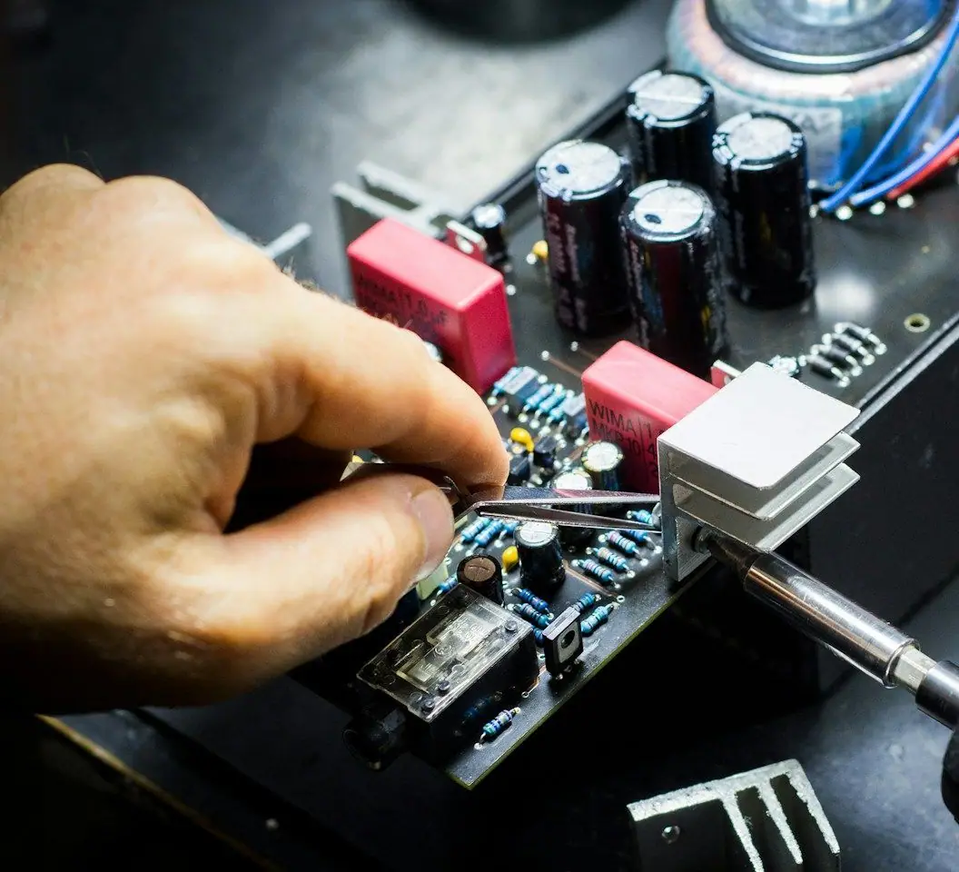 Tweezers placing a component on an electronic circuit board